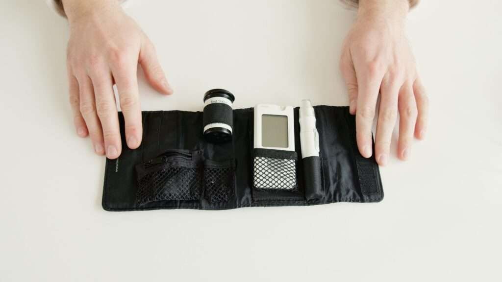 Close-up of hands holding a diabetic glucometer kit on a white table for blood sugar testing.